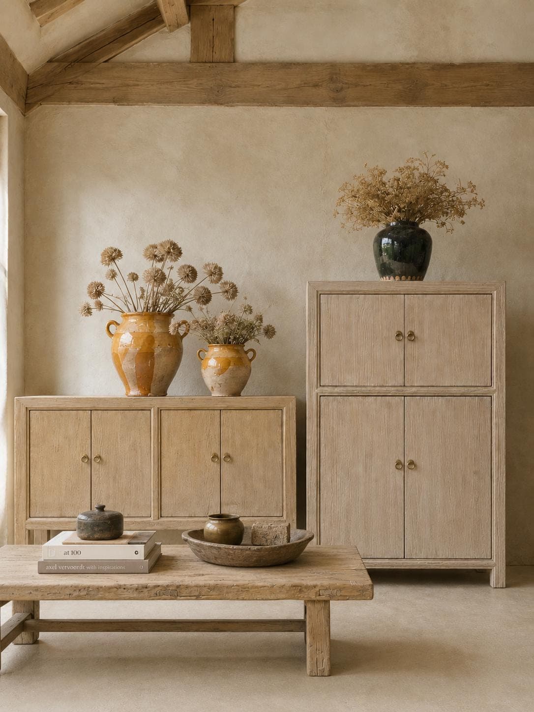 Pale elm cabinets and a low reclaimed coffee table styled with glazed confit pots