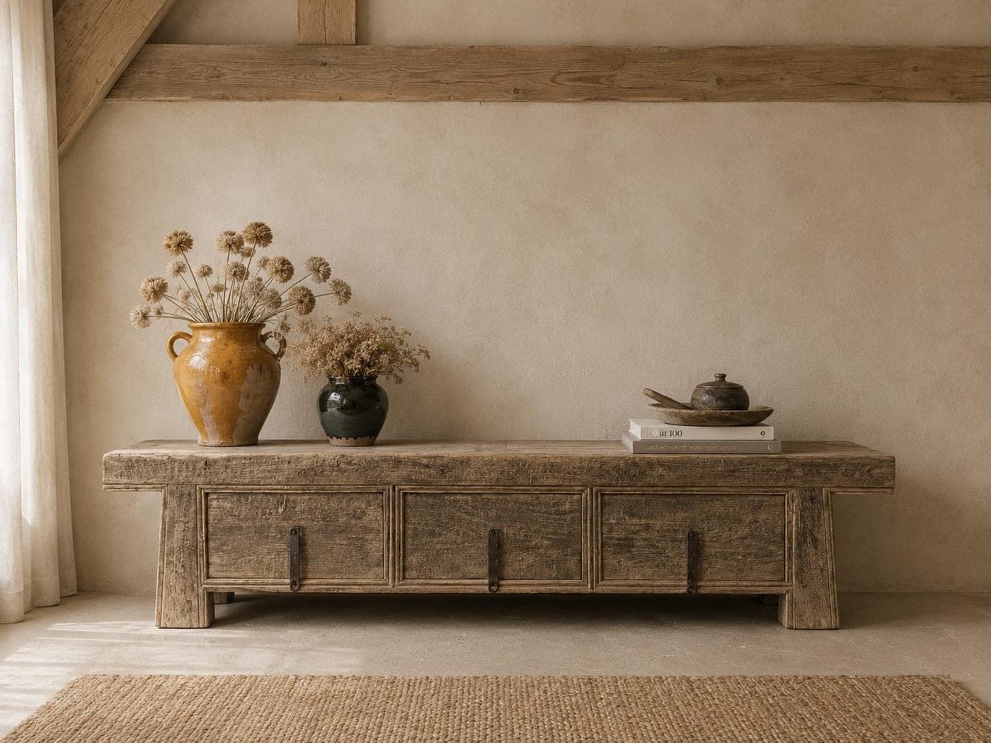 Low reclaimed elm sideboard styled with dried flowers in glazed stoneware urns